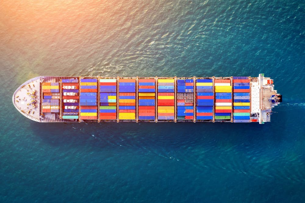 Aerial view of a container ship at sea, part of Tycoon Trading's supply network